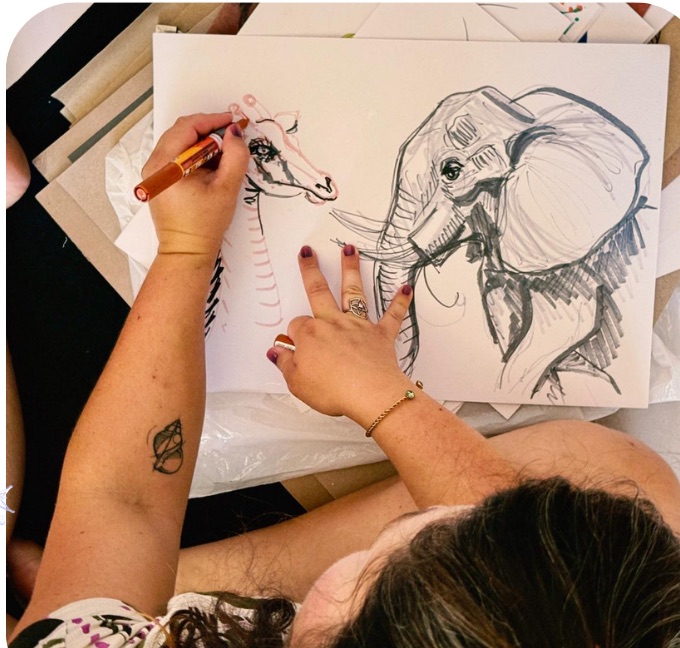 Julia dessinant un éléphant au marqueur sur une grande feuille