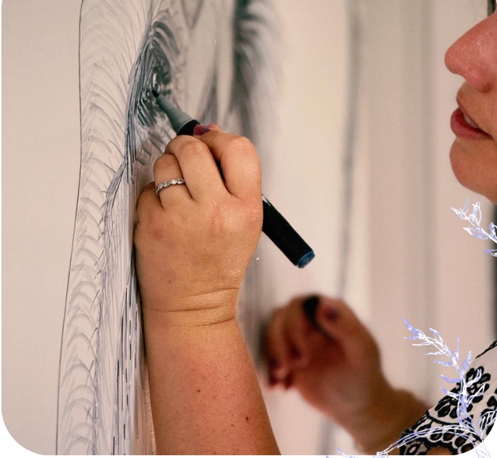Julia traçant un motif au marqueur directement sur un mur